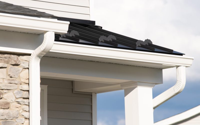 New rain gutter on a home against blue sky rain facade white